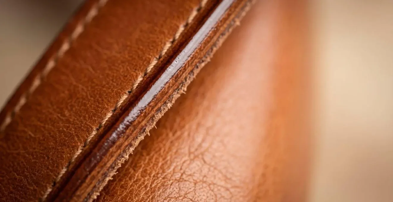 Gros plan sur la tranche d'un sac en cuir de qualité montrant une finition astiquée impeccable