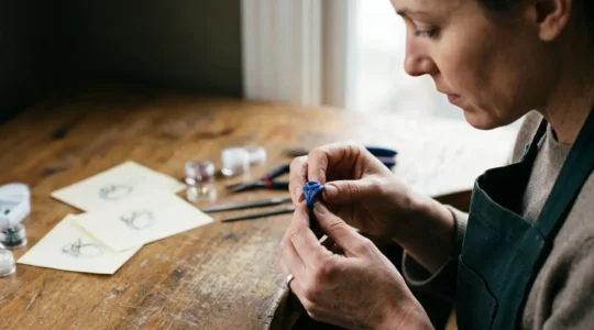 Artisan bijoutier concentré travaillant sur un prototype de bijou personnalisé dans son atelier