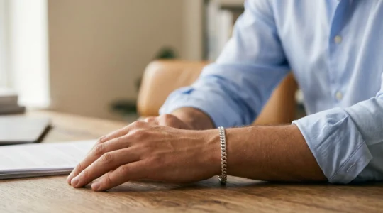 Gourmette masculine en argent massif portée avec élégance discrète sur un poignet d'homme en chemise sobre
