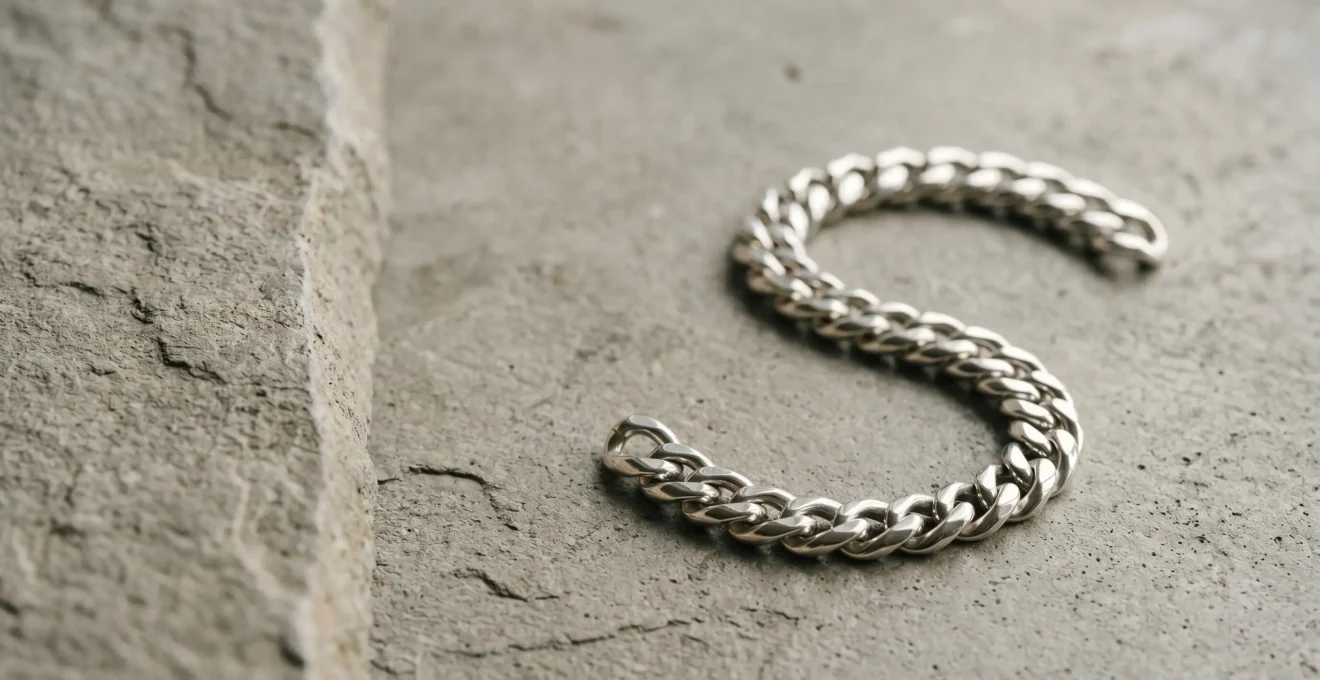 Gourmette masculine en argent massif posée sur une surface minérale, style épuré et raffiné